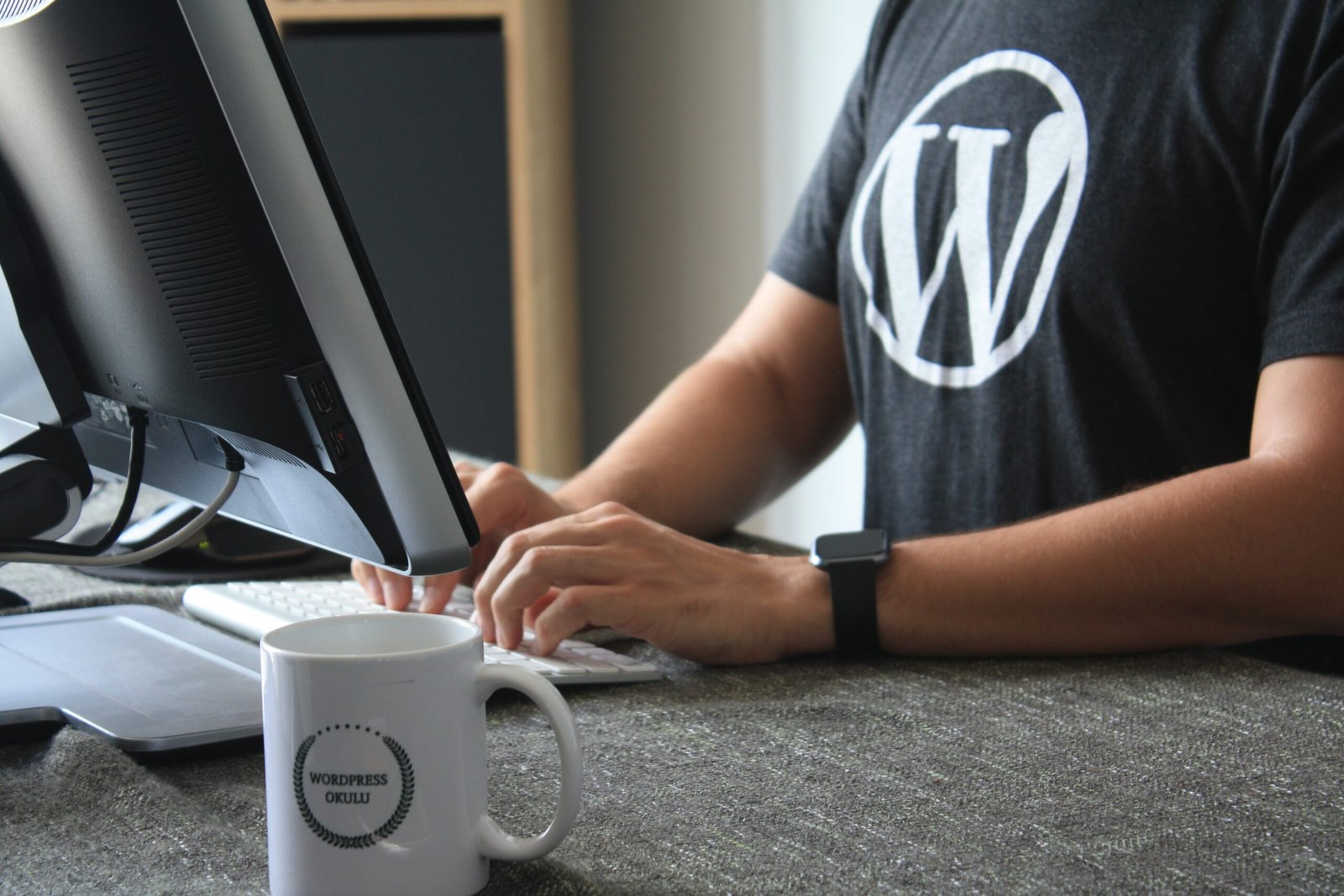 7 Reasons to Use WordPress to Build Your Amazing Site person in black and white t-shirt using computer