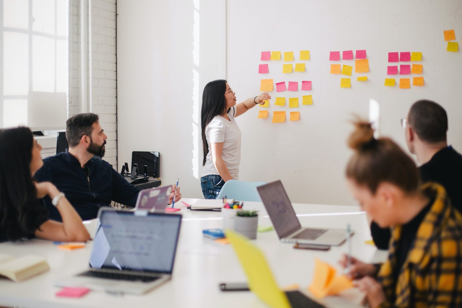 Find Out How to Get Your Amazing Digital Product Market woman placing sticky notes on wall
