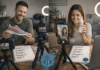 What is UGC & How Real People Are Getting Paid for It Two creators filming a UGC review: man holds a gray shoe with an orange swoosh while camera and ring light are set up behind him; notebook with price ideas visible on the table.